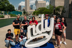 A group of students pose next to the Indy statue in downtown Indianapolis.